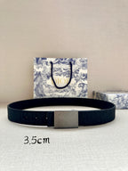Dior belt with dark leather strap and silver rectangular buckle, flat lay.