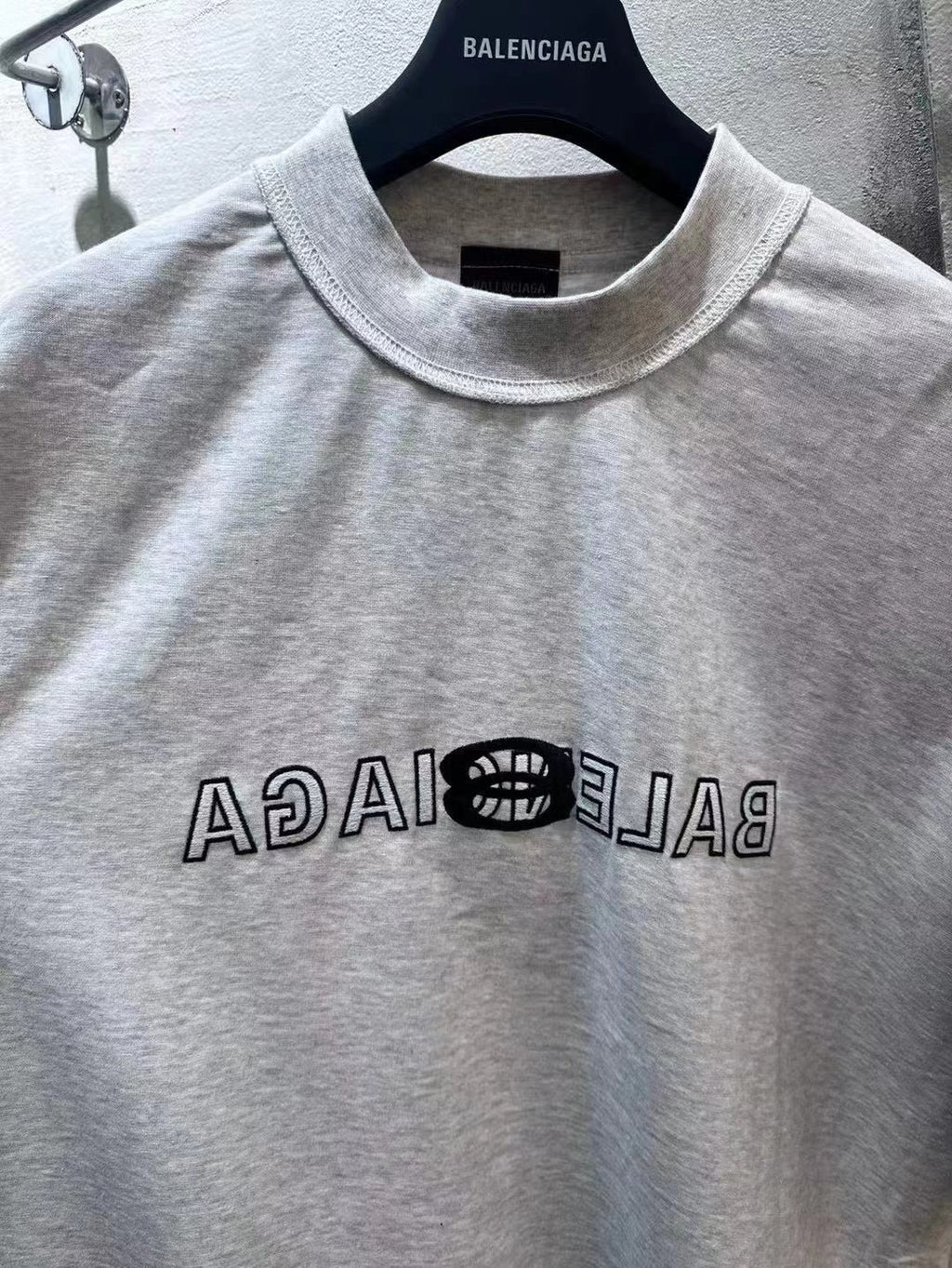Light gray Balenciaga short-sleeve T-shirt close-up of crew collar and front logo