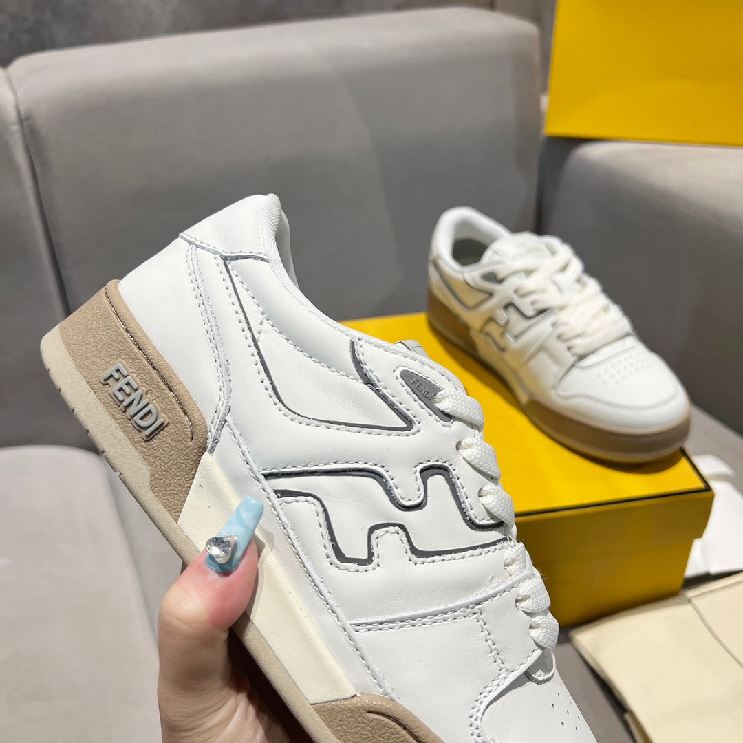 White unisex sneakers with tan suede heel panel and black logo trim detail.