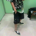 Black cargo shorts with layered pocket panels and drawstring hem
