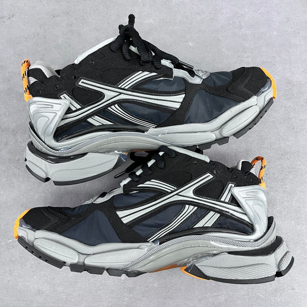 Balenciaga unisex sneakers pair, side-by-side view in black and silver with orange accents