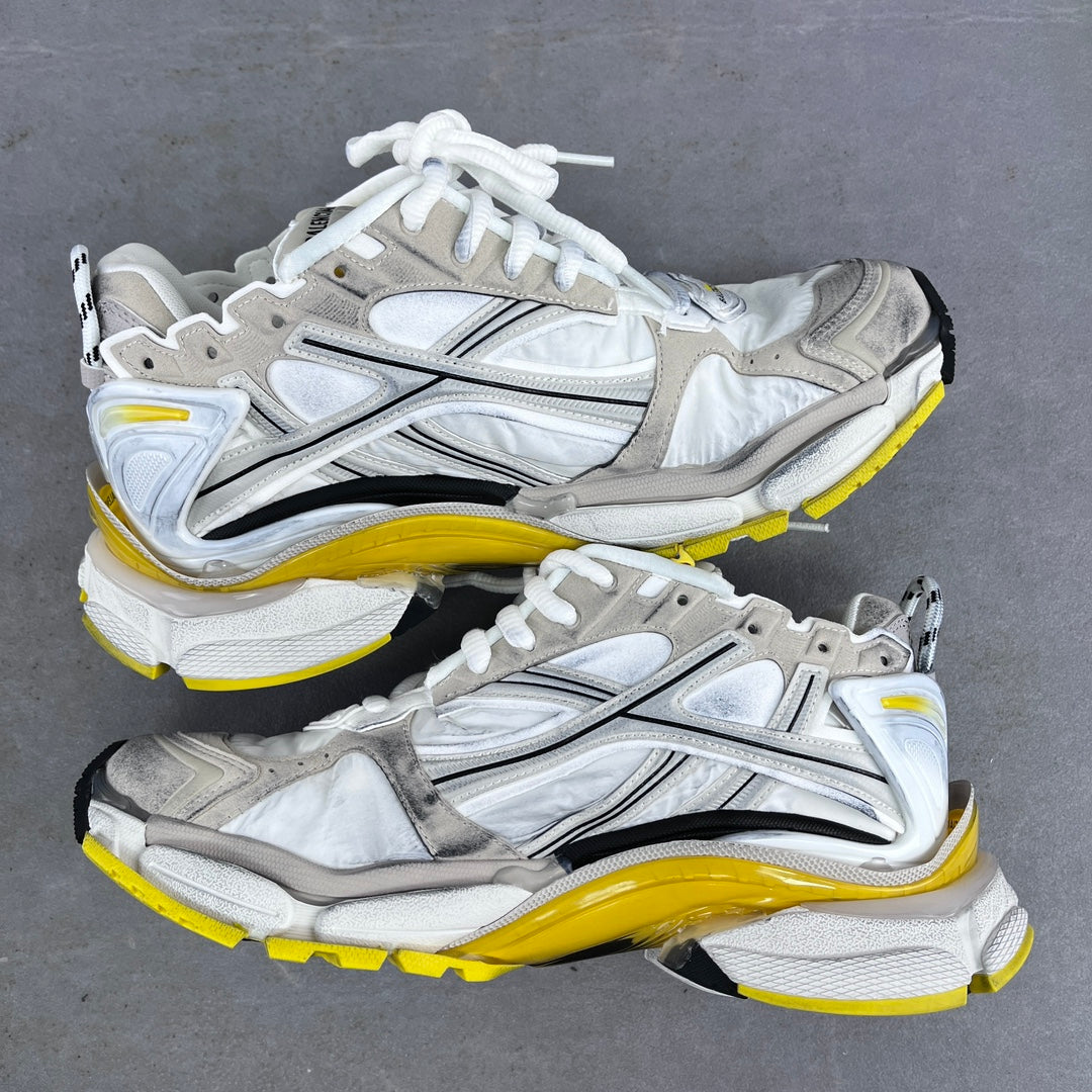 Unisex lace-up sneakers in white and silver with yellow midsoles and chunky soles.
