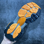 Outsole of blue and tan sneakers with deep tread pattern.
