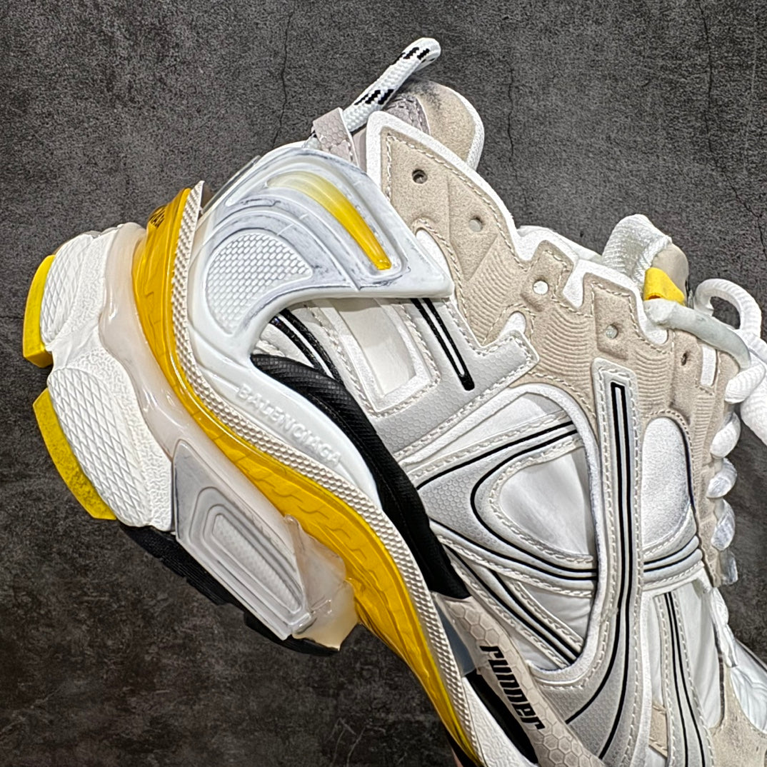 Balenciaga unisex sneakers angled side view, white upper with gray overlays and yellow trim
