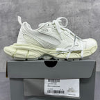 White lace-up sneakers with mesh sides and chunky pale sole on box