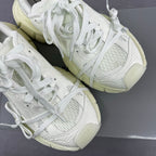 White lace-up sneakers with textured uppers and chunky light-cream soles