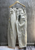 Balenciaga pants, light wash denim with colorful paint splatter, front view with pockets