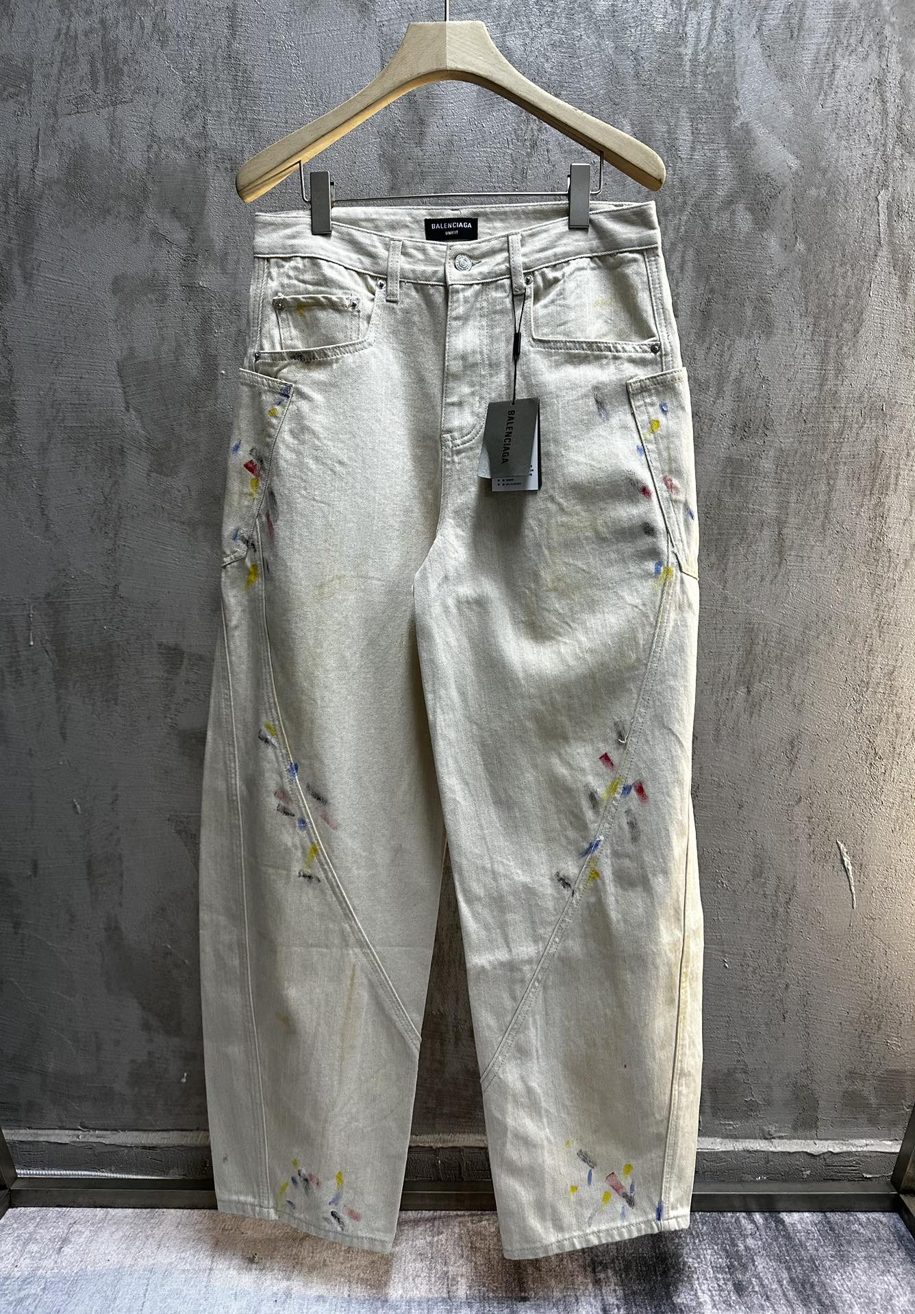 Balenciaga pants, light wash denim with colorful paint splatter, front view with pockets