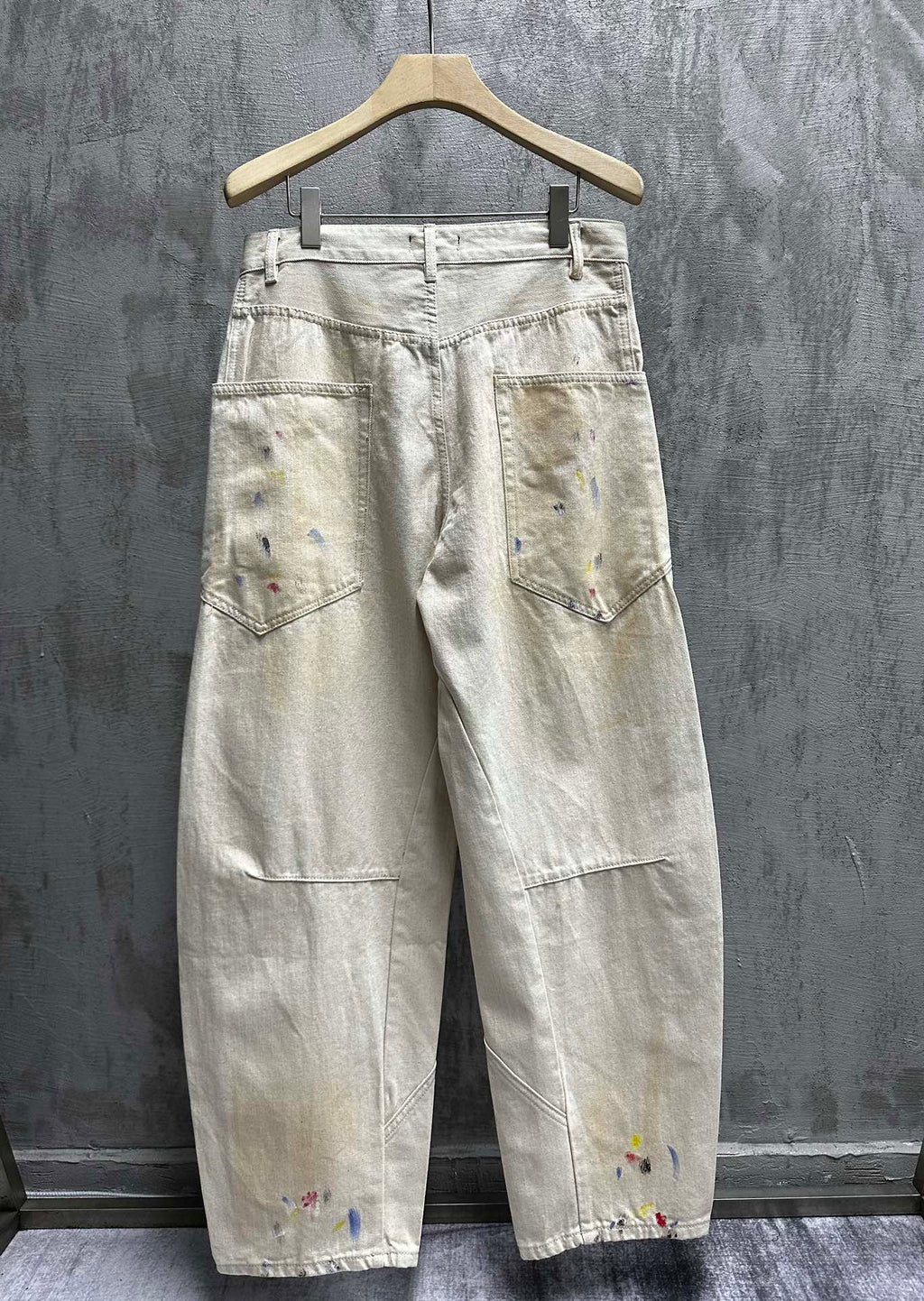 Balenciaga pants, light wash denim with colorful paint splatter, back view with back pockets