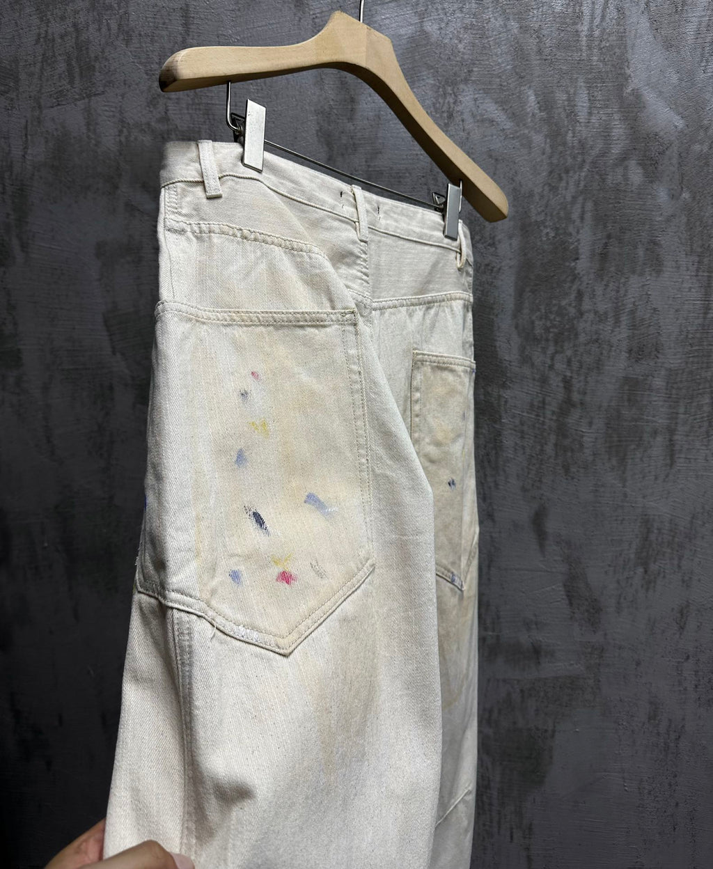 Balenciaga pants, light wash denim with paint splatter, back view close-up of pockets