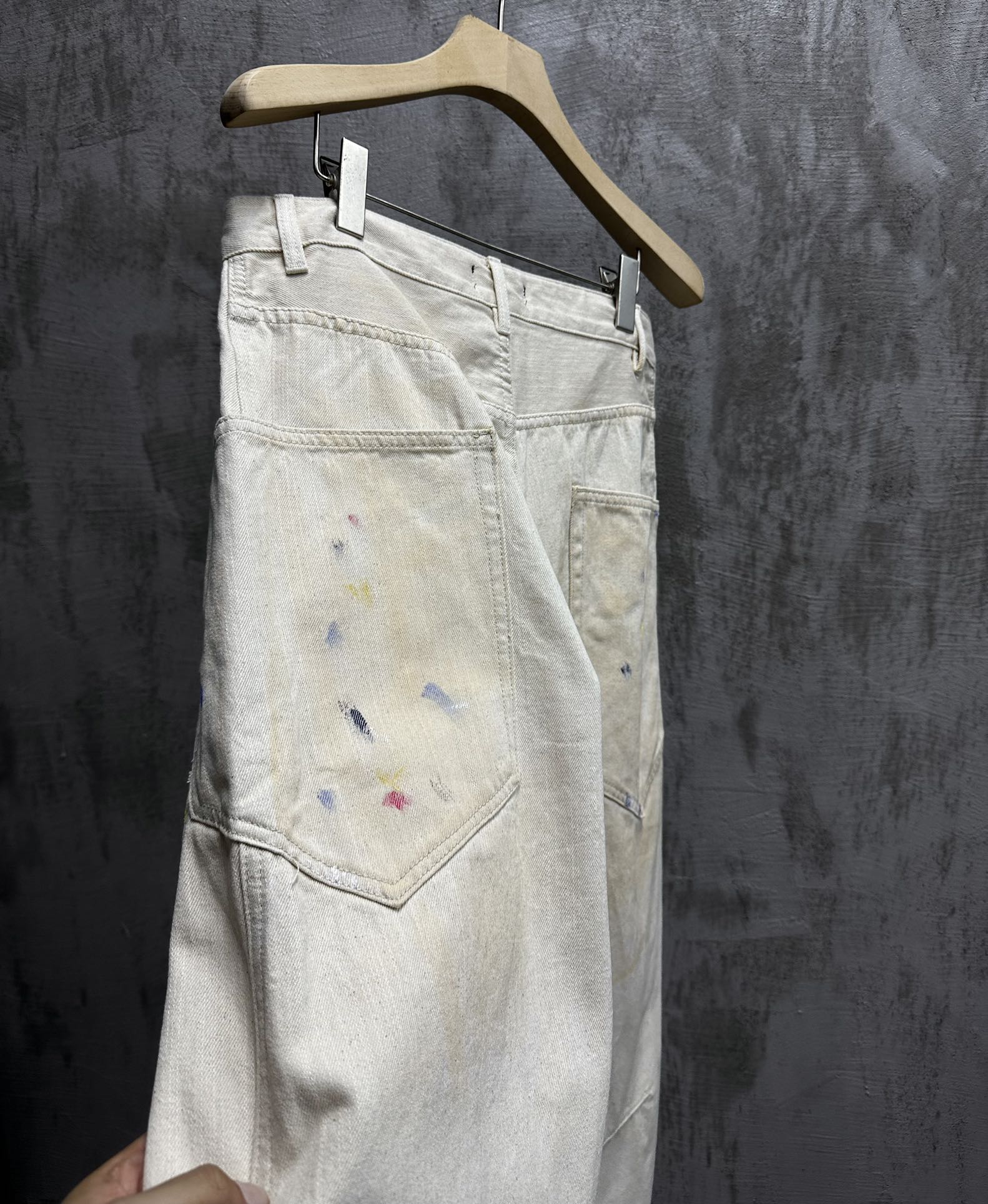 Balenciaga pants, light wash denim with paint splatter, back view close-up of pockets
