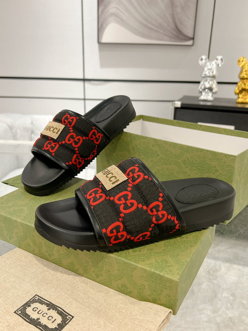 Pair of black Gucci slide sandals with red GG jacquard band and textured sole