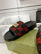 Black slide sandals with red GG patterned strap on black cushioned footbed