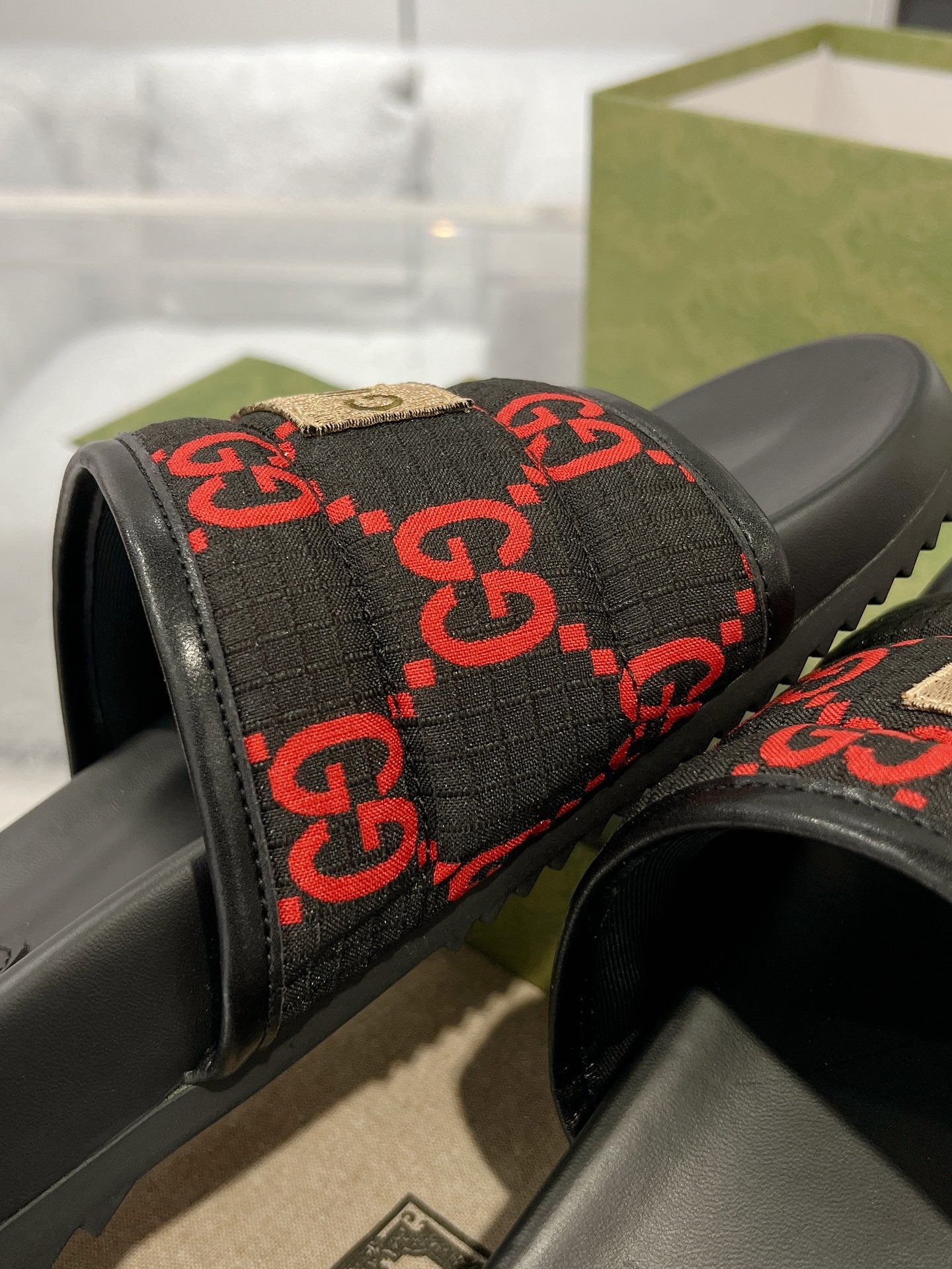 Black slide sandals with red GG monogram jacquard strap and beige accent trim