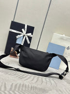Black crossbody bag with wide strap, zip closure, and logo triangle on front