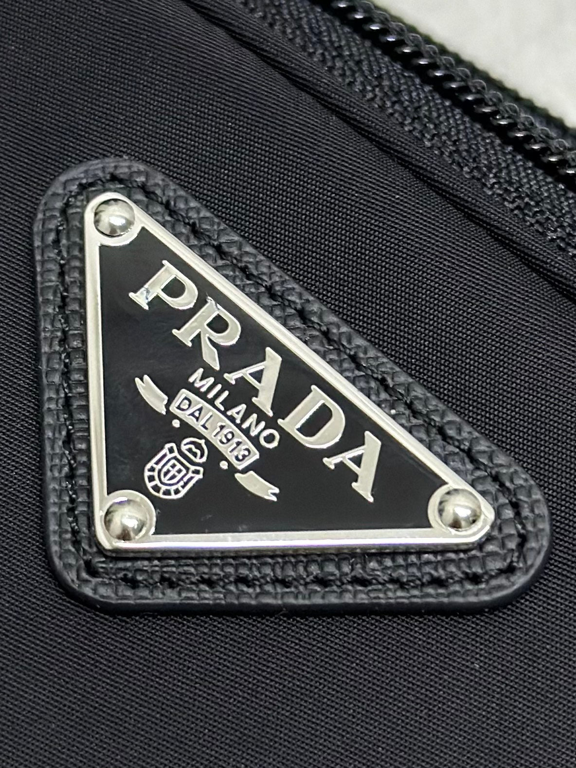 Black bag front logo patch with PRADA MILANO metal plate and stitched trim