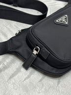 Black crossbody bag front with metal buckle and triangular PRADA logo plaque