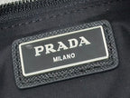 Black logo patch with PRADA MILANO metal plate on crossbody bag