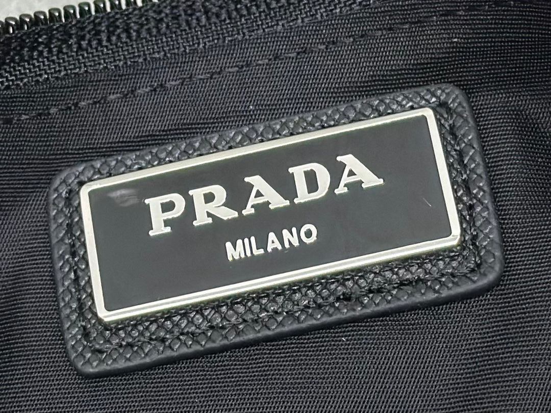 Black logo patch with PRADA MILANO metal plate on crossbody bag