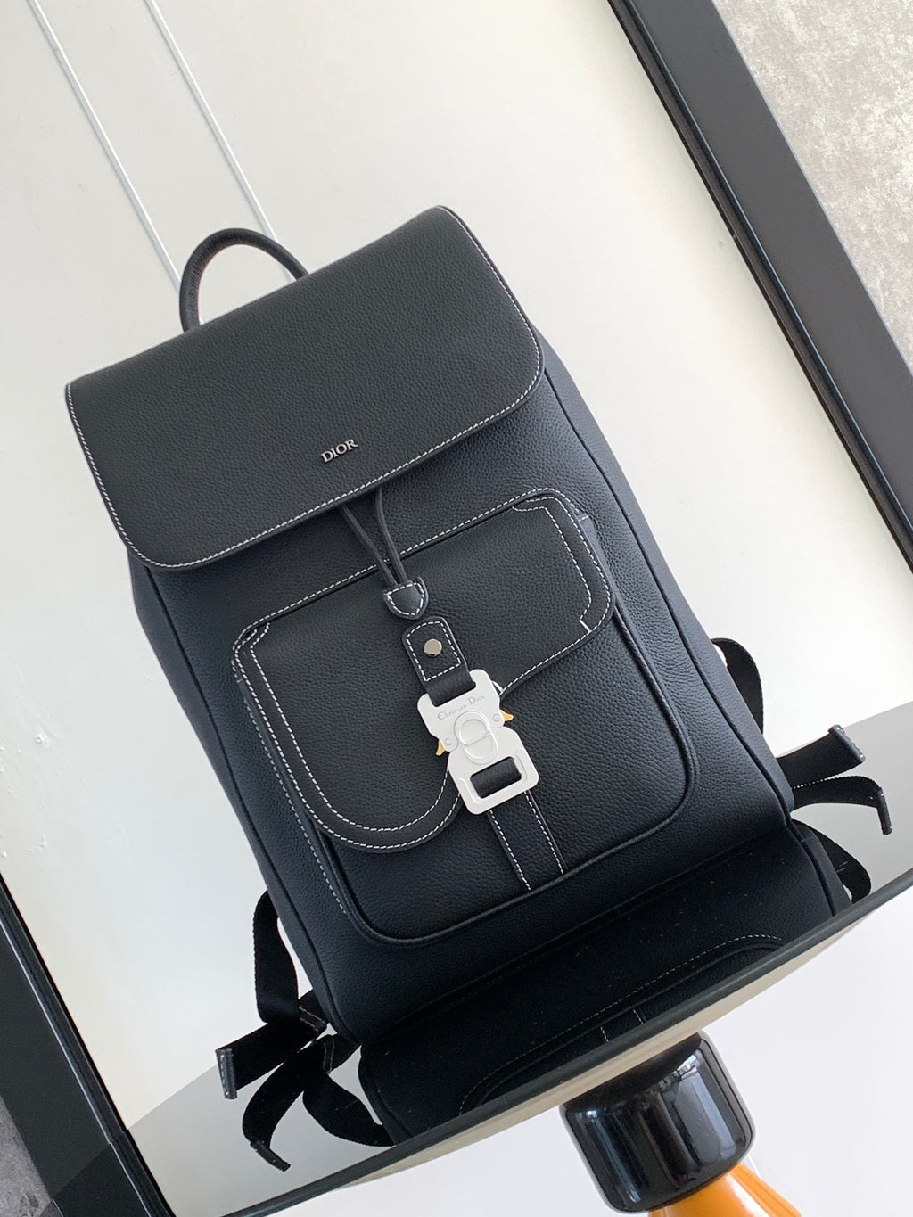 Dior leather backpack with flap and stitched pocket, front buckle strap details