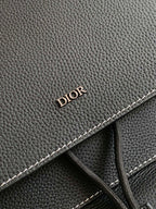 Black leather backpack detail with “DIOR” embossing and contrast stitching