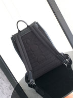 Black backpack interior panel with quilted lining and front strap with metal hardware