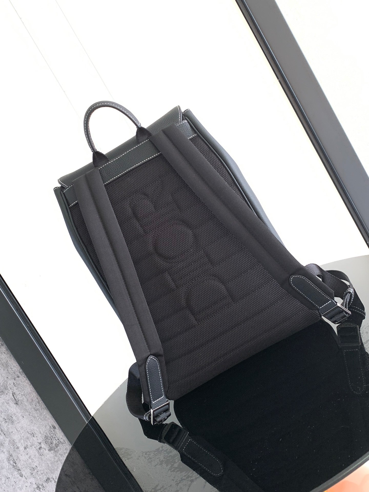 Dior leather backpack interior view with quilted fabric lining and side strap