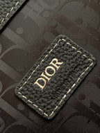 Dior leather backpack close-up of Dior-branded tab with contrast edge stitching