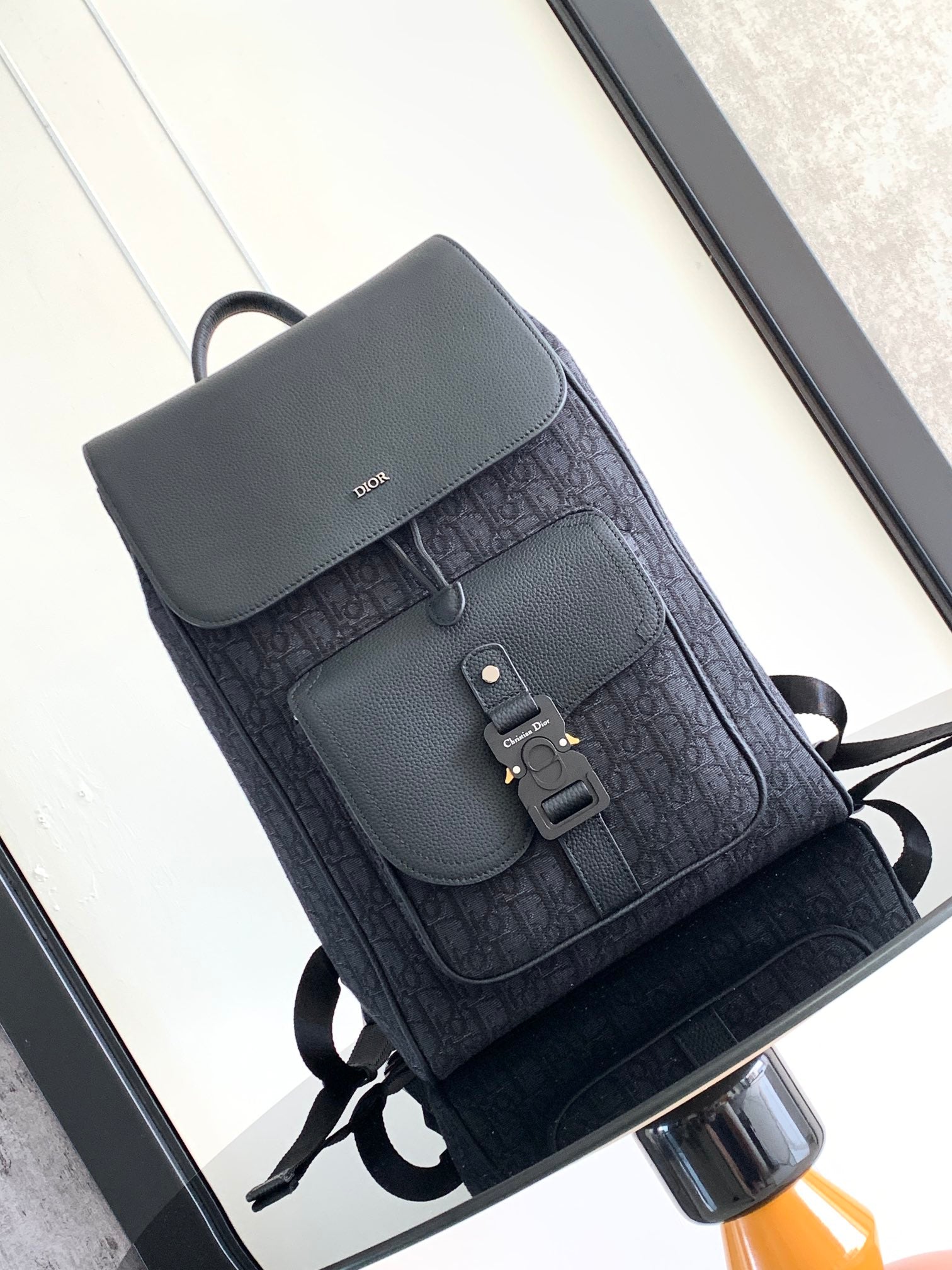 Dior men’s monogram backpack with front flap, magnetic buckle, and adjustable straps