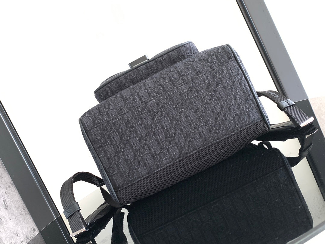 Dior bag front view, dark monogram texture with adjustable shoulder straps