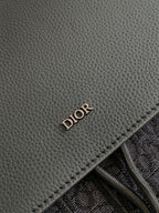 Dior men’s leather backpack panel with embossed “DIOR” stamp and stitched edge