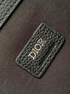 Dior men’s leather patch with embossed “DIOR” lettering on textured monogram panel