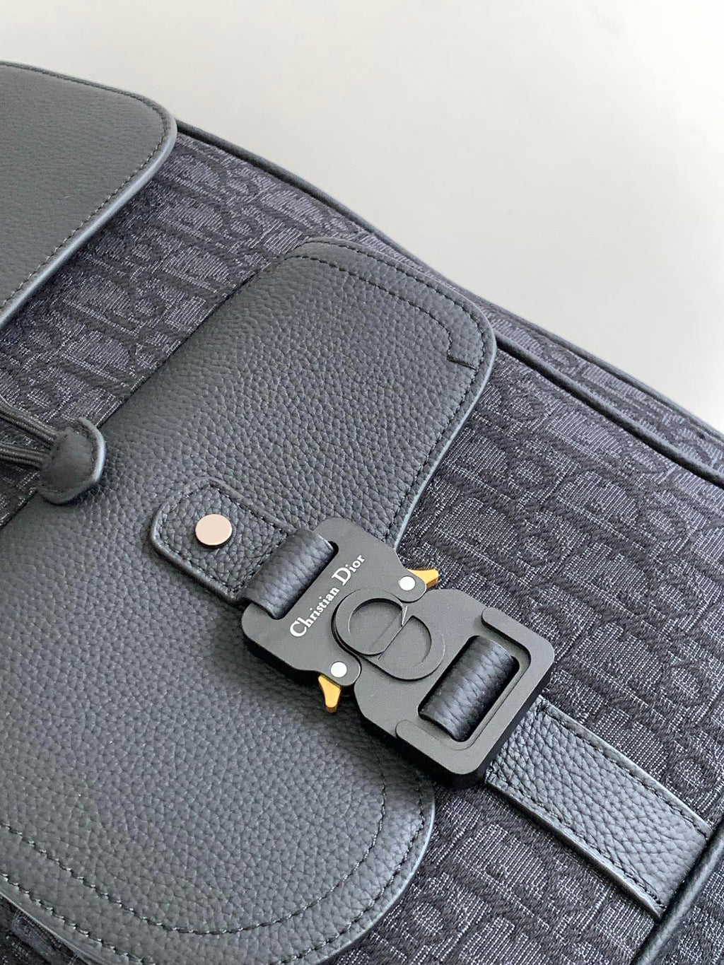 Dior bag close-up, logo key charm on gray leather flap and monogram fabric