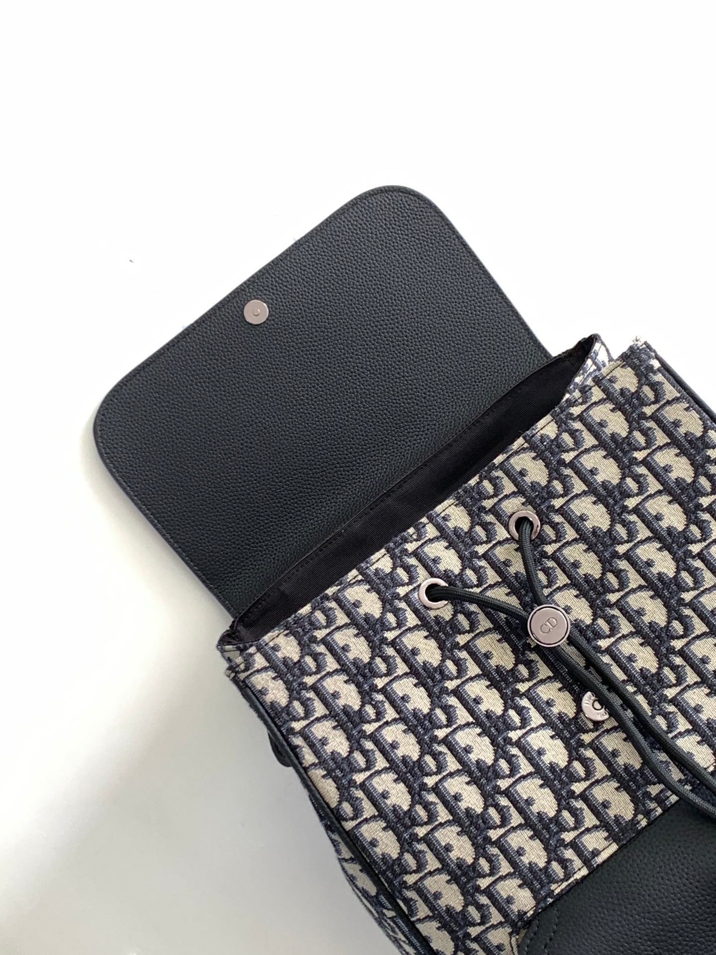 Men's Dior backpack with navy-and-black Oblique canvas and black leather snap cover