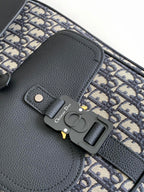 Dior backpack close-up: black leather flap, metal clasp, and navy monogram trim