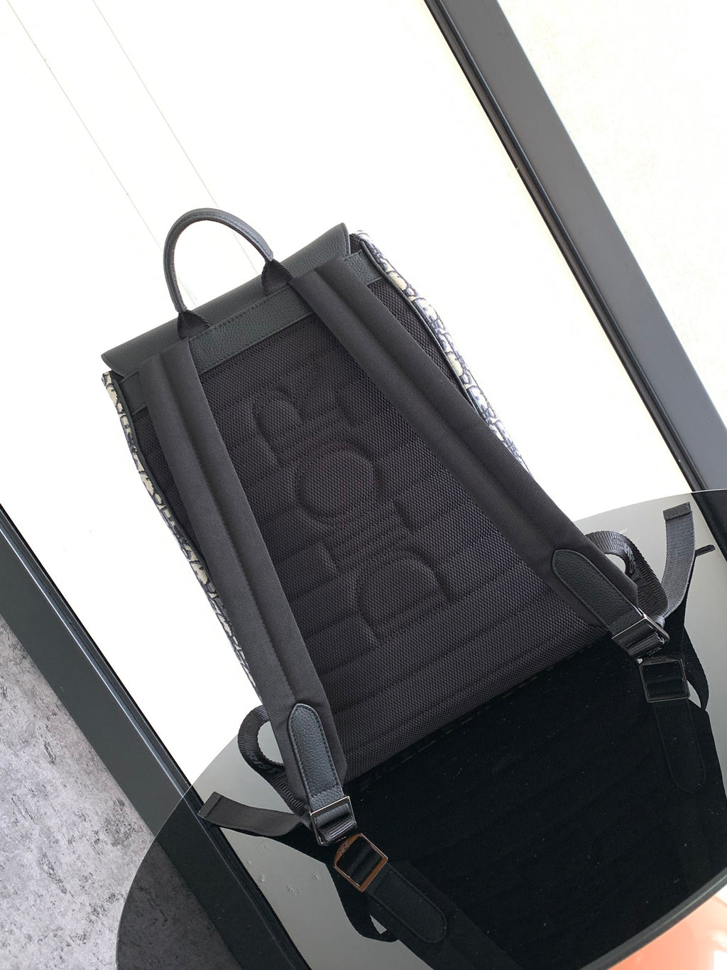 Dior backpack open top view with black quilted interior and adjustable straps