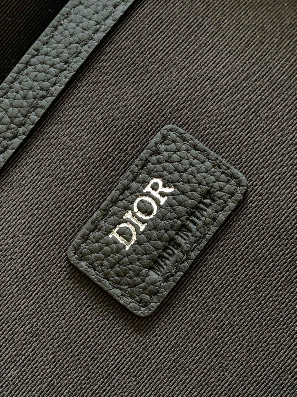 Dior backpack logo patch on black textured leather, quilted panel