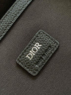 Dior backpack close-up of black leather patch with Dior logo and quilted texture