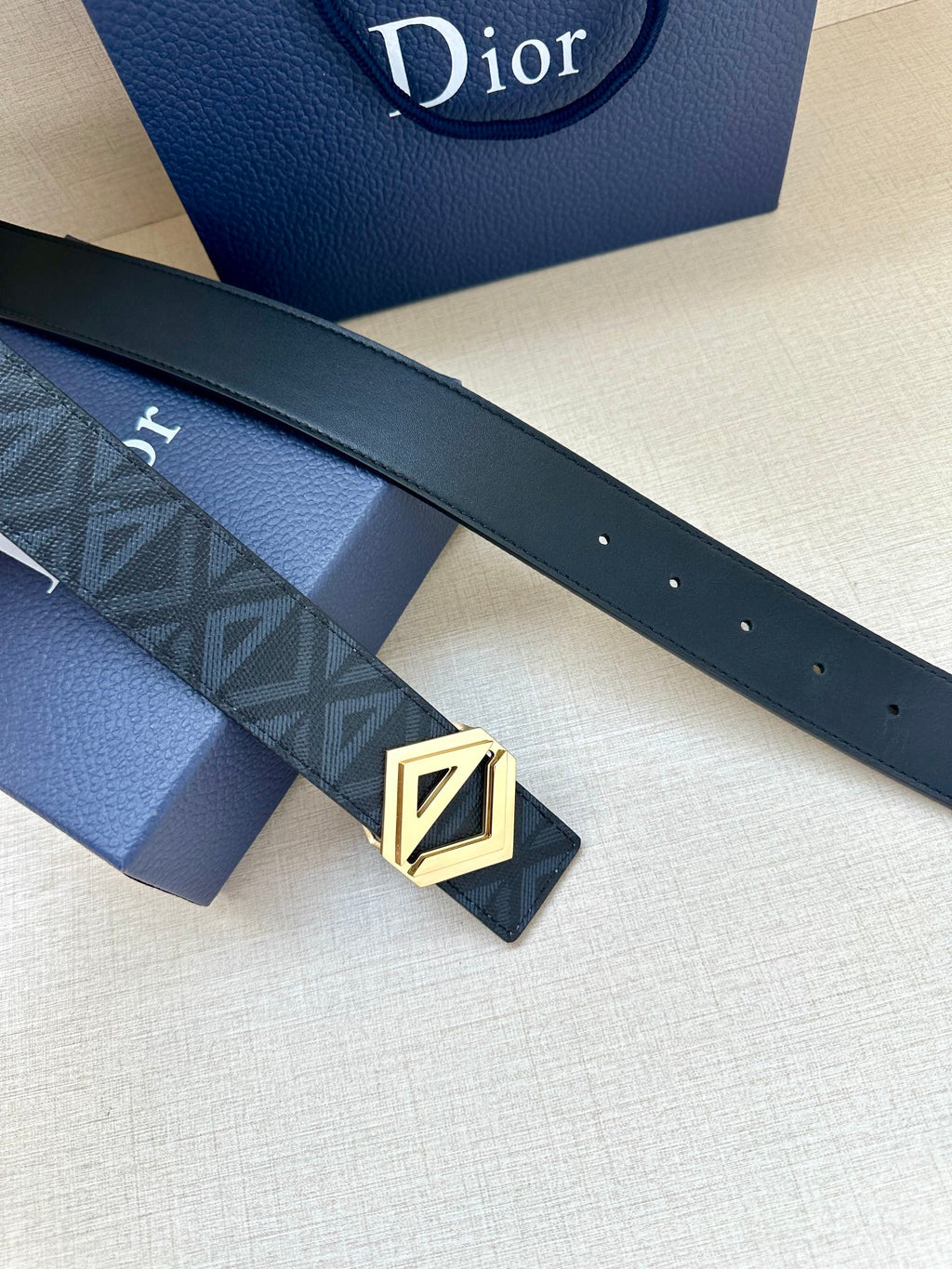Dior belt with dark strap, embossed pattern, and gold-tone LV buckle