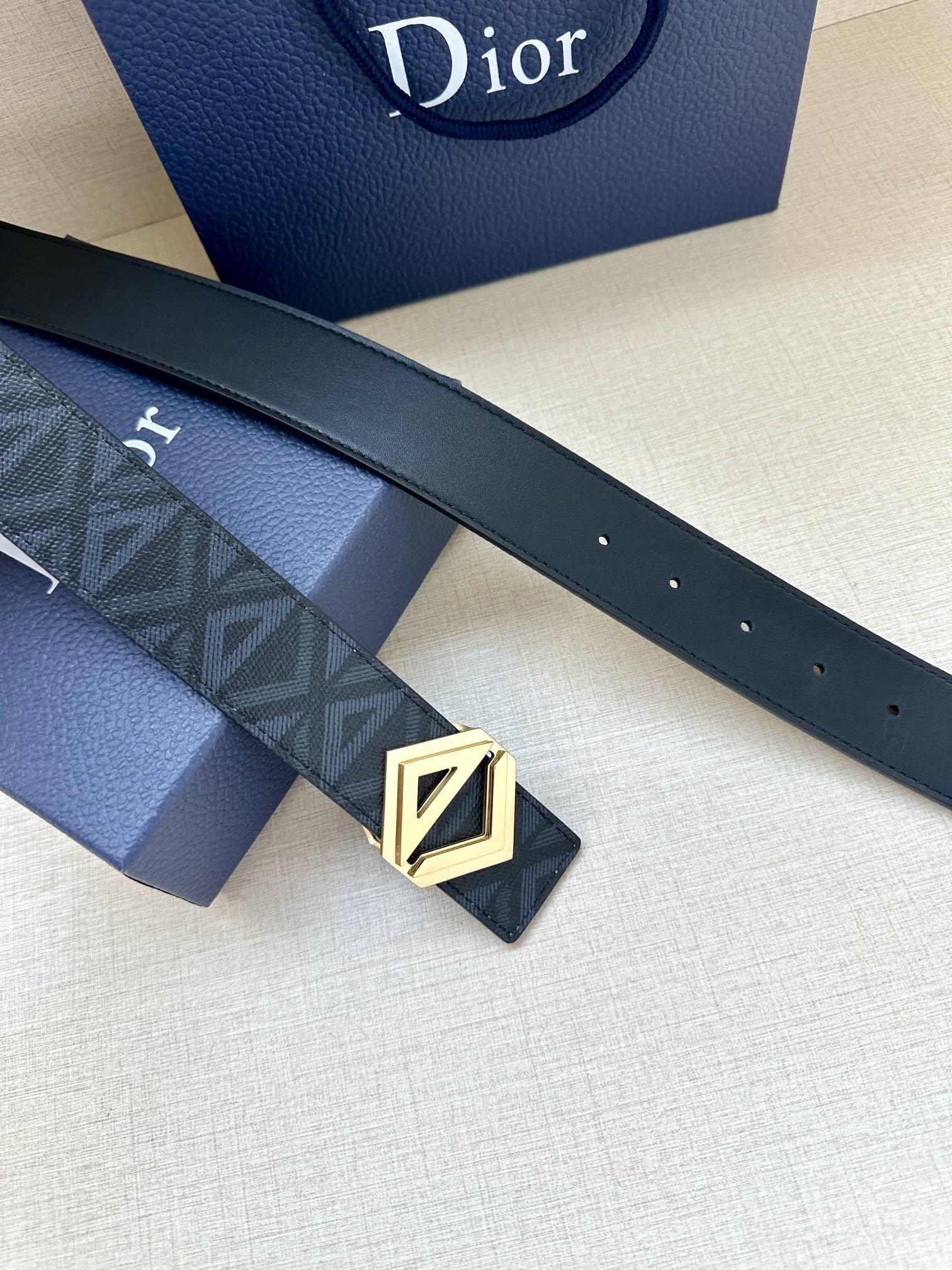 Dior belt with dark strap, embossed pattern, and gold-tone LV buckle