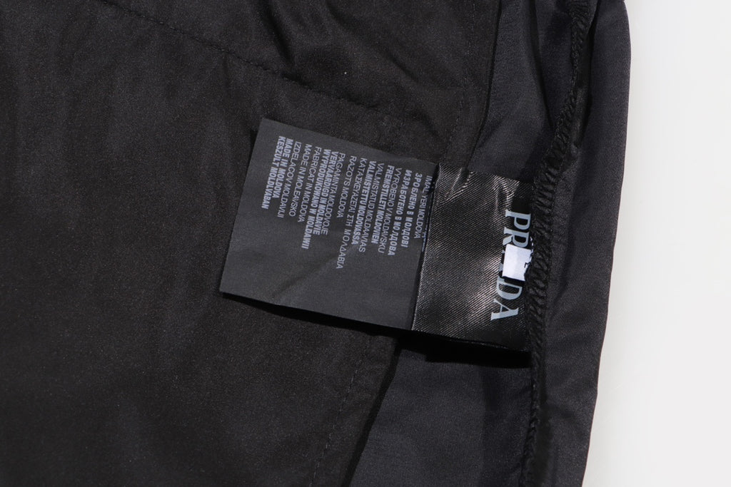 Prada care label on black cargo shorts near pocket