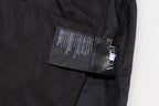 Prada care label on black cargo shorts near pocket