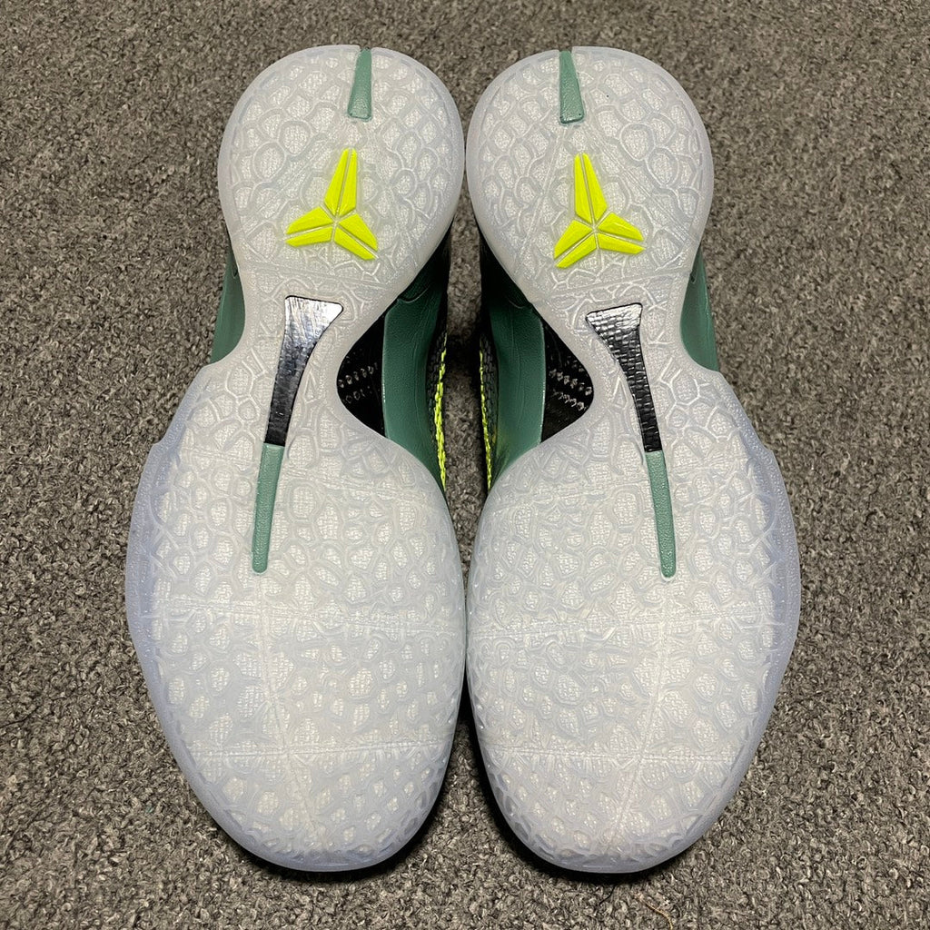 White shoe heels with neon-yellow logos and green heel stripes on a textured sole