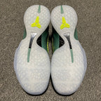 White shoe heels with neon-yellow logos and green heel stripes on a textured sole