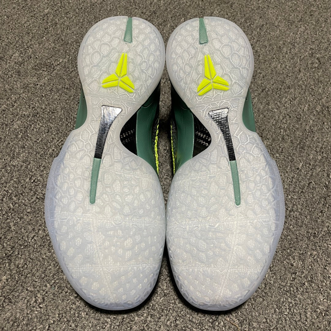 White shoe heels with neon-yellow logos and green heel stripes on a textured sole