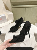 Black pointed-toe heeled sandals with bow-tied ankle straps