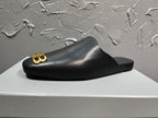 Black slide sandal showing gold BB logo on the front strap and molded footbed.