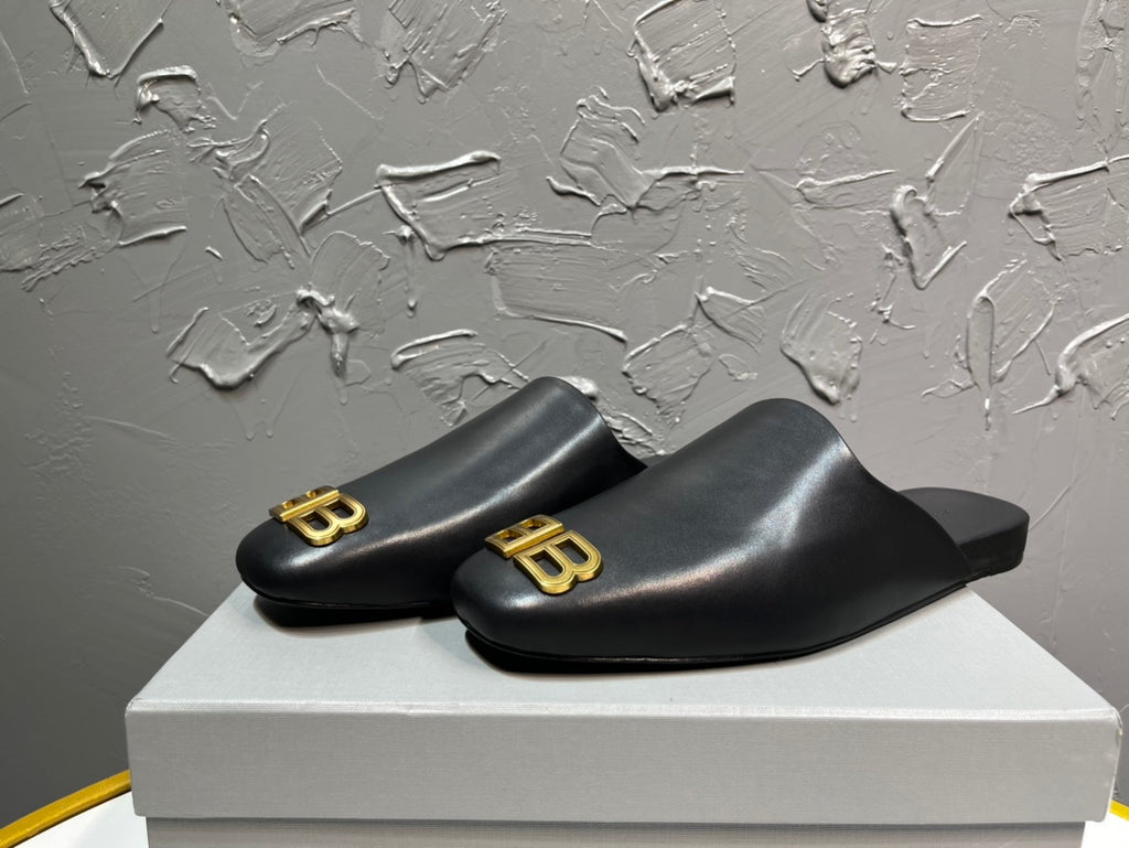 Black slide sandals with gold BB logo detail on a wide front strap.