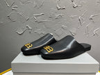 Black slide sandals with gold BB logo detail on a wide front strap.