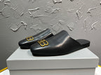 Black leather slide sandals with gold B-logo accents, open toe, low profile